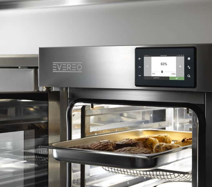 Tray of food being inserted in hot holding system unox evereo to keep them at service temperature