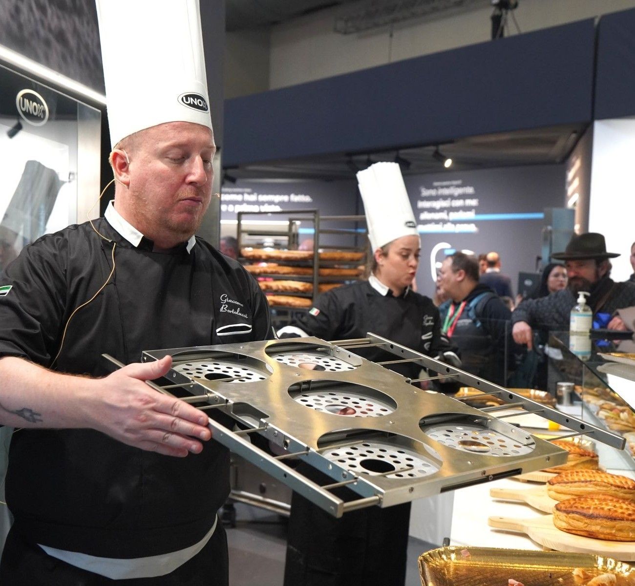 Chef présentant une plaque professionnelle pour panettone utilisée dans les fours mixtes Unox