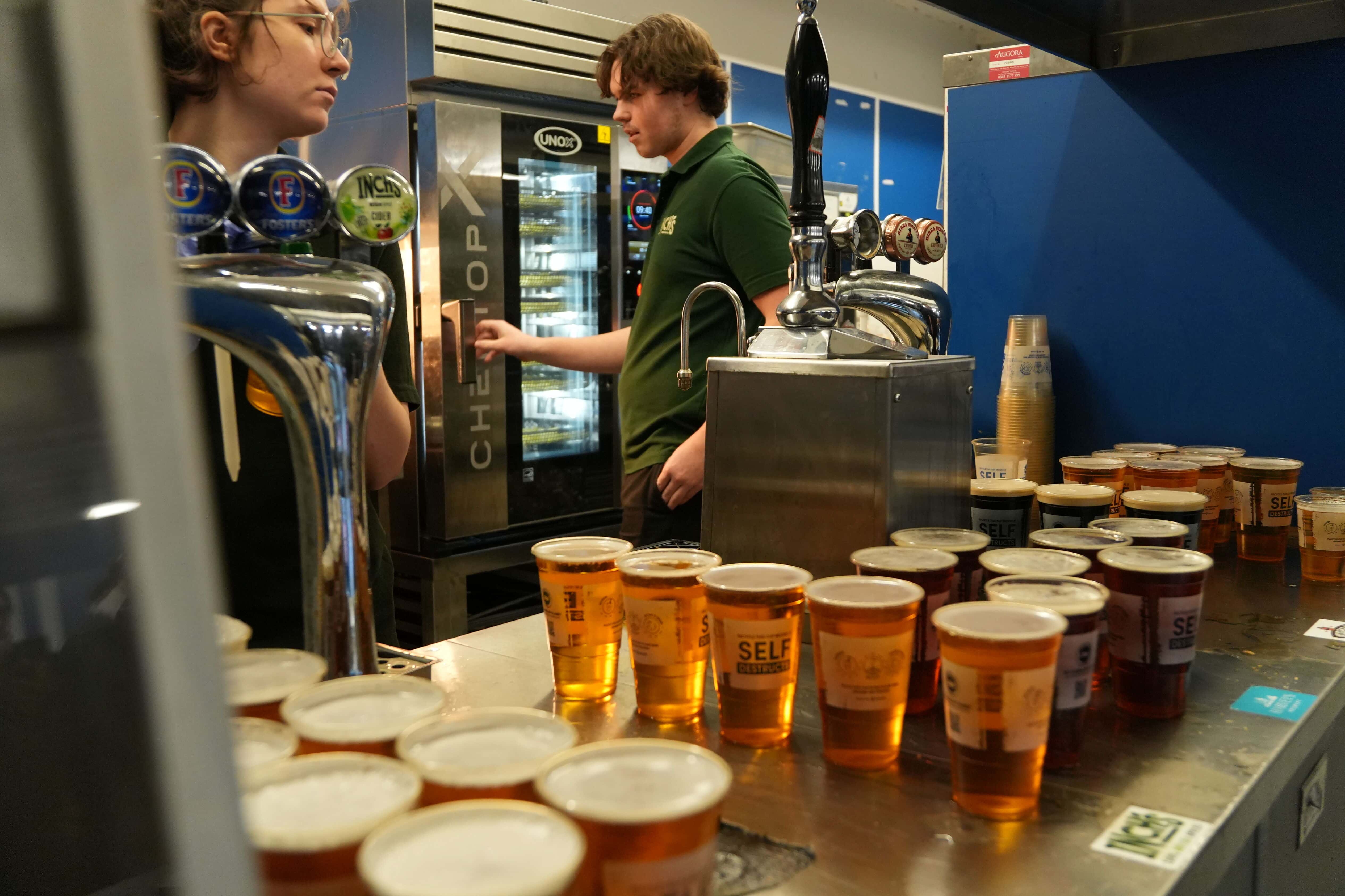 Stadium pub kitchen with beers on the foreground counter, operator opening unox cheftopx combi oven door in the background.