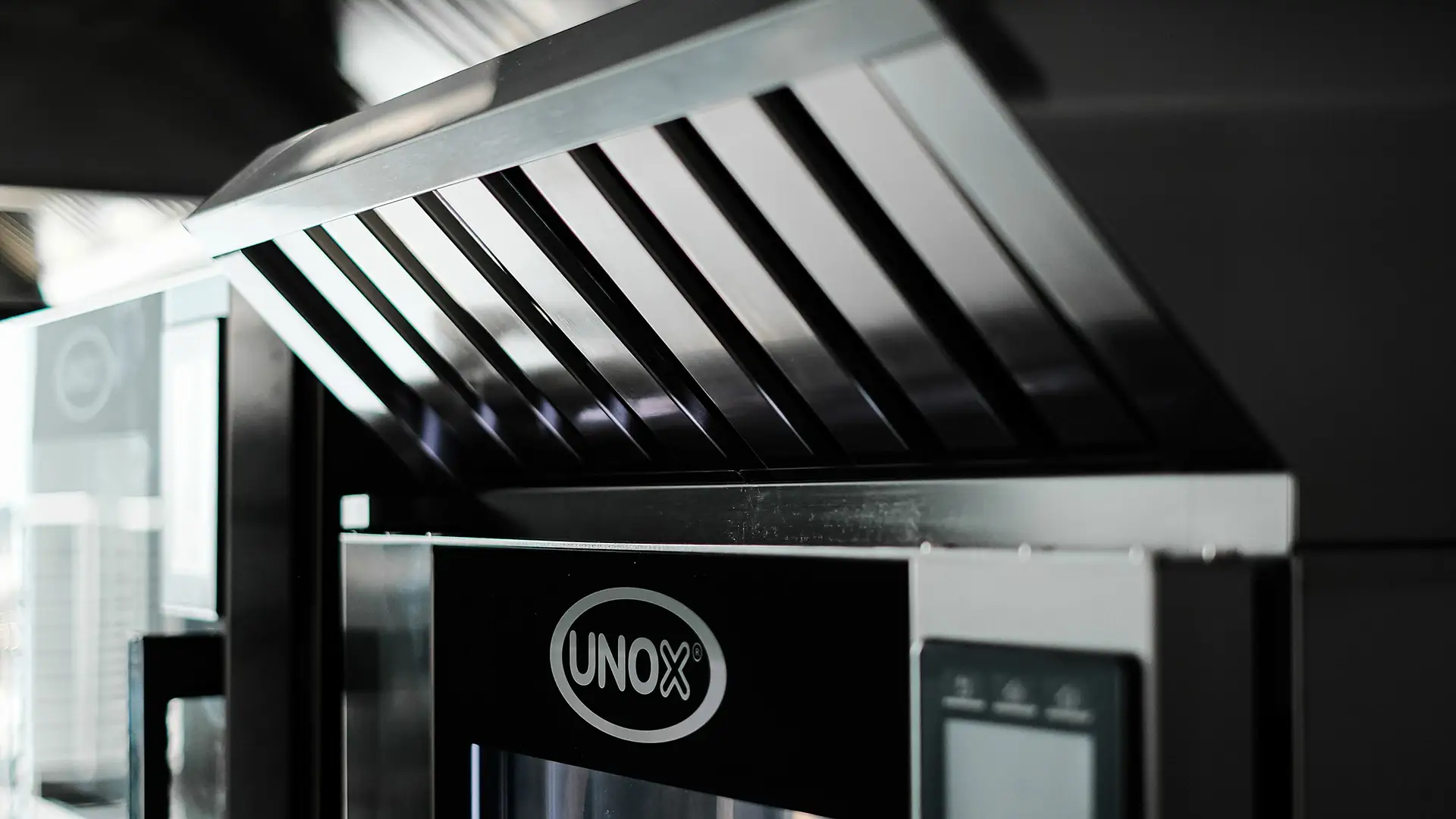 condensation hood positioned above a Unox commercial oven in a kitchen
